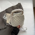 White quilted bucket bag with rhinestones and woven handle in a stylish handheld display - Off-white