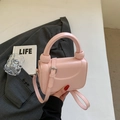 Détail d'un mini sac à main rose pâle avec poignée à nœud rond et finitions argentées - Rose