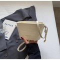Detailaufnahme der cremefarbenen Krokodilmuster Eimertasche mit goldenem Anhänger - Cremeweiß
