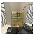 Close-up of gold crocodile texture small crossbody bag with metal cross and chain detail - Gold