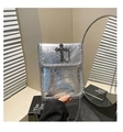 Close-up of silver crocodile texture bag with black cross emblem and metal chain strap - Silver