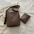 Set borsa a secchiello in pelle marrone scuro minimalista con pochette su sfondo beige - Marrone