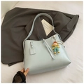 Detail van lichtblauwe zachte leren tote tas met parelketting en clown-bedeltje - Blauw met hanger