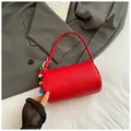 Red pebbled leather cylinder crossbody bag with stylish shoulder strap and colorful charm - Red with Pendant