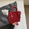 Schicke rote geflochtene Eimertasche mit silbernem Metallanhänger und Schultergurt - Burgunderrot