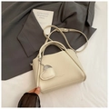 Gros plan du sac seau en cuir grainé blanc cassé avec pendentif cœur et bandoulière - Blanc Cassé