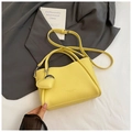 Dettaglio borsa a secchiello gialla con trama litchi e ciondolo a cuore su blazer grigio - Con Ciondolo / Giallo