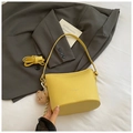 Schicke gelbe Eimertasche aus strukturiertem Leder mit Bärenanhänger und Schultergurt - Gelb