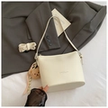 Minimalistische beige Eimer-Tasche aus genarbtem Leder mit Plüschbär-Anhänger - Weiß
