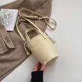 Dettaglio della borsa a secchiello in pelle beige con chiusura a coulisse e manici - Giallo