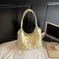 Primer plano de un bolso Hobo amarillo pálido con encaje de corazón blanco y un lazo - Amarillo
