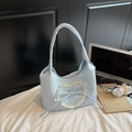 Bolso hobo azul claro con corazón de encaje y lazo sobre sábanas blancas - Azul