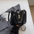 Schwarze Bucket-Tasche mit Krokodilprägung, Silberverschluss und modischer Metallkette - Schwarz