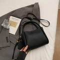 Minimalist black lychee leather bucket bag with dog charm and adjustable strap - Black