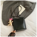 Detalle de bolso cubo de cuero negro con logotipo SNMI y colgante de perrito beige - Negro Con Colgante