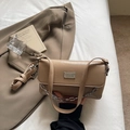 Macro shot of stylish beige faux leather baguette bag with silver chain and metal hardware - Khaki