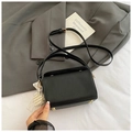 Détail du sac boîte en cuir grainé noir avec charm perle et clous dorés de protection - Noir Avec Pendentif