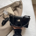 Dettaglio borsa in pelle cerata nera lucida con catena d'argento e targhetta in metallo - Nero