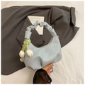 Detail of light blue crescent dumpling bag with floral charm and pleated handle - Blue