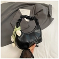 Detail of black hobo bag with pleated handle and white tulip charm in a stylish setting - Black