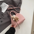 Detail van roze mini-tas van lychee-leer met een schattige berenpop als decoratie - Roze Met Hanger