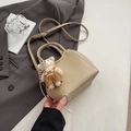 Detail van abrikooskleurige emmertas met lychee-textuur en schattige berenhanger - Khaki Met Hanger