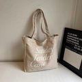Detalle del bolso tote de lona beige con texto Sunday Tender Care y correa de hombro - Gris Beige