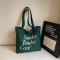 Detailopname van de donkergroene canvas draagtas met witte Sunday-belettering - Groen