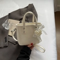 Bolso tipo cubo beige crema con textura plissettata y colgante de corazón de perlas - Blanco Roto