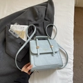 Light blue faux crocodile leather bag with gold hardware and logo on white bedding - Blue Without Charm