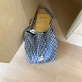 Dettaglio della borsa tote in tela a quadretti bianchi e blu con etichetta OUR FAVE - Quadri Blu / Blu