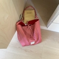 Dettaglio della borsa tote a quadretti rossi con etichetta e chiusura a fiocco - Quadretti Rossi / Rosso