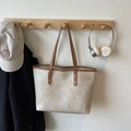 Minimalist beige tote bag with stone texture and brown leather straps on wall hook - Khaki No Pendant