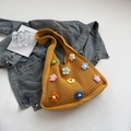 Dettaglio di fiori colorati 3D all'uncinetto su una borsa tote gialla in maglia - Giallo