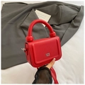 Close-up of red lychee leather bag with chunky handle and spherical metal sphere detail - Red