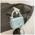 Close-up of a light blue litchi pattern mini handbag with silver logo and ball handle - Blue