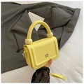 Detailed view of yellow lychee leather bag with spherical hardware on the top handle - Yellow