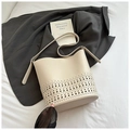 Chic beige bucket bag featuring geometric laser-cut hollow patterns and a long strap - White