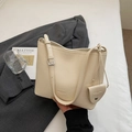 Detailed macro view of cream pebbled leather texture on minimalist bucket bag - Off White