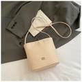 Minimalistische beige gevlochten emmertas met metalen logo en dunne schouderriem - Roze Zonder Hanger