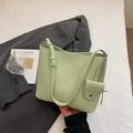 Detail view of light green lychee leather bucket bag with brand embossing and small pouch - Green