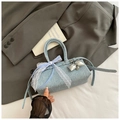 Détail d'un sac à main en jean bleu clair avec nœud en dentelle et breloque cœur - Bleu Denim