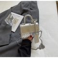 Detail of silver metallic handbag with woven texture and elegant chain strap on a blazer - Silver Small