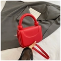Detalle del bolso rojo con textura de lichi y detalles de bolas y asa ancha - Rojo