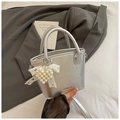 Detail of silver crinkled handbag with pearl heart pendant and white lace bow decoration - Silver