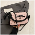 Detailed shot of pink shoulder bag with black bow print and silver heart charm pendant - Pink and Black