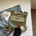 Detailansicht der hellgrünen Messenger-Tasche aus Nylon mit Fronttasche und Gurt - Grün
