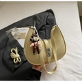 Detail showing beige moon bag texture with pearl chain and metallic twist lock clasp - With Ornament / Yellow