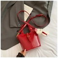 Fashionable red leather bucket bag with top handle and plush bear charm detail - Red