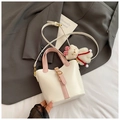 Chic cream bucket bag with pink handles and a cute plush bear charm, crossbody style - White
